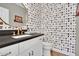 Stylish powder room with designer wallpaper, a round mirror, and modern fixtures at 5406 E Charleston Ave, Scottsdale, AZ 85254