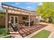 Charming covered back patio with brick pavers, green grass, and furniture at 5528 E Virginia Ave, Phoenix, AZ 85008