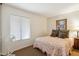Simple bedroom with floral bedding, fan, and natural light from the window at 5528 E Virginia Ave, Phoenix, AZ 85008