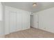 This bedroom features neutral carpet, a single light fixture, and a double door closet at 5625 E Dodge St, Mesa, AZ 85205