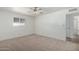 This bedroom features a neutral carpet, a ceiling fan, and a window with blinds at 5625 E Dodge St, Mesa, AZ 85205