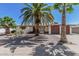 Charming single-story home featuring desert landscaping with mature palm trees and a two-car garage at 5625 E Dodge St, Mesa, AZ 85205