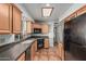 Well-lit kitchen with tile floors, wood cabinets, black appliances, and a skylight at 5625 E Dodge St, Mesa, AZ 85205