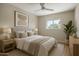 Bright bedroom featuring neutral tones, a ceiling fan, and a window with a view of lush greenery at 5738 N 34Th S Dr, Phoenix, AZ 85017