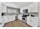 Bright kitchen featuring white cabinets, stainless steel appliances, light countertops and hardwood floors at 6108 S Wilson Dr, Chandler, AZ 85249