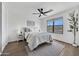 Cozy bedroom with neutral tones, a ceiling fan, a large window and hardwood floors at 6108 S Wilson Dr, Chandler, AZ 85249
