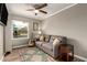 Cozy bedroom features a gray sofa, wood look floors, and a bright window at 6128 E Portia St, Mesa, AZ 85215