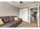 Comfortable bedroom features a gray sofa, wood look floors, and a view to the backyard at 6128 E Portia St, Mesa, AZ 85215
