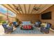 Spacious covered patio featuring plush seating, ceiling fans, and a mounted TV, perfect for outdoor living at 6128 E Portia St, Mesa, AZ 85215