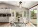 Bright dining area with white table and chairs, a chandelier, and bay window that overlooks the backyard at 6128 E Portia St, Mesa, AZ 85215