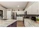Modern kitchen with stainless steel appliances, sleek granite counters, and white cabinets at 6128 E Portia St, Mesa, AZ 85215
