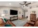 Open-concept living room with wood flooring, leather furniture, a ceiling fan, and natural light from the entry at 6128 E Portia St, Mesa, AZ 85215