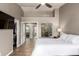 Bright main bedroom featuring wood flooring, neutral walls, ceiling fan and doors leading to the ensuite and closet at 6128 E Portia St, Mesa, AZ 85215