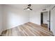 Bedroom showcasing light wood floors, white walls, a ceiling fan, and a doorway to another room at 6228 E Blanche Dr, Scottsdale, AZ 85254
