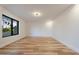 Empty bedroom boasts light hardwood floors, large window, recessed lighting, and neutral tones at 6228 E Blanche Dr, Scottsdale, AZ 85254