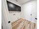 Clean laundry room with black cabinets and light hardwood floors at 6228 E Blanche Dr, Scottsdale, AZ 85254