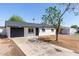 Charming single-story home featuring a well-maintained exterior and a spacious front yard with mature tree at 6733 N 49Th Ave, Glendale, AZ 85301