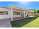 Inviting backyard shows covered patio, exterior windows, well-kept lawn and garden box at 7214 W Columbine Dr, Peoria, AZ 85381
