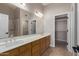 Bathroom with a long vanity, double sinks, large mirror and a walk in closet at 7214 W Columbine Dr, Peoria, AZ 85381
