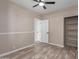 Bright bedroom has ceiling fan, modern floors, closet with shelving, and two entry doors at 7214 W Columbine Dr, Peoria, AZ 85381