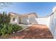 Single-story house with desert landscaping, and a white privacy gate enclosing a side patio area at 7214 W Columbine Dr, Peoria, AZ 85381