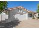 Single-story home with a two-car garage and a driveway, showcasing low-maintenance desert landscaping at 7214 W Columbine Dr, Peoria, AZ 85381