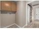 Laundry room shows storage cabinets, washer hookups, barn door to bathroom, and modern flooring at 7214 W Columbine Dr, Peoria, AZ 85381