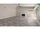 Cozy living room with wood floors, a fireplace, and large windows providing natural light at 7214 W Columbine Dr, Peoria, AZ 85381