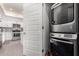 Modern stacked washer and dryer set with the kitchen visible through the doorway at 7300 E Earll Dr # 1022, Scottsdale, AZ 85251