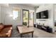 Bright living room featuring a leather sofa, hardwood floors, and a sliding glass door to the balcony at 7300 E Earll Dr # 1022, Scottsdale, AZ 85251