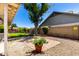Private backyard with brick patio, mature tree, gravel landscaping and block wall at 7515 W Sweetwater Ave, Peoria, AZ 85381