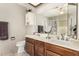 Well-lit bathroom features a double sink vanity, a large mirror and view of the shower at 7515 W Sweetwater Ave, Peoria, AZ 85381