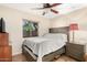 Well-lit bedroom includes a large window with blinds, ceiling fan and hardwood floors at 7515 W Sweetwater Ave, Peoria, AZ 85381