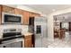 Kitchen with stainless steel appliances, wooden cabinetry, and a view into the dining room at 7515 W Sweetwater Ave, Peoria, AZ 85381