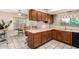 Galley-style kitchen featuring dark wood cabinets and stainless steel appliances. A breakfast nook provides a place to eat at 7515 W Sweetwater Ave, Peoria, AZ 85381