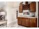 Wet bar featuring wood cabinets, wine rack, and sink. The room has neutral paint colors and tiled floors at 7515 W Sweetwater Ave, Peoria, AZ 85381