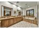 Bathroom featuring dual sinks, a soaking tub, wooden cabinets and natural stone tile at 7780 E Golden Eagle Cir, Gold Canyon, AZ 85118