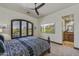 Comfortable bedroom with plantation shutters, en-suite bathroom access, and a modern ceiling fan at 7780 E Golden Eagle Cir, Gold Canyon, AZ 85118