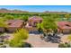 Aerial view of the front of a home with three-car garage near a golf course with desert landscaping at 7780 E Golden Eagle Cir, Gold Canyon, AZ 85118