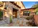 Inviting front entrance with stone porch, rustic wooden door, and desert landscaping at 7780 E Golden Eagle Cir, Gold Canyon, AZ 85118