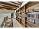 Upstairs hallway with hardwood beams, built-in bookshelves, and staircase with decorative tile at 7780 E Golden Eagle Cir, Gold Canyon, AZ 85118