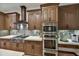 Close-up of kitchen featuring stainless steel appliances, custom cabinets, and decorative backsplash at 7780 E Golden Eagle Cir, Gold Canyon, AZ 85118