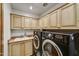Laundry room with black washer and dryer and light wood cabinets at 7780 E Golden Eagle Cir, Gold Canyon, AZ 85118