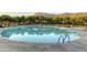 Large swimming pool surrounded by lounge chairs, lush greenery and mountain views at Superstition Mountain Golf and Country Club at 7780 E Golden Eagle Cir, Gold Canyon, AZ 85118