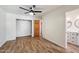 This bedroom features wood floors, a closet and a view into the bathroom at 7813 N 17Th Dr, Phoenix, AZ 85021