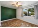 Cozy bedroom with wood-look floors, a bright wall, and a large window offering neighborhood views at 7813 N 17Th Dr, Phoenix, AZ 85021