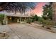 Charming home exterior with a spacious driveway and well-maintained landscaping at sunset at 7813 N 17Th Dr, Phoenix, AZ 85021