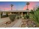 Inviting home with mature landscaping, covered porch, and decorative outdoor lighting at 7813 N 17Th Dr, Phoenix, AZ 85021