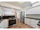 Spacious kitchen with stainless steel appliances, white cabinets, and wood-look floors, with an eat-in kitchen area at 7813 N 17Th Dr, Phoenix, AZ 85021