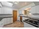 Updated kitchen featuring white cabinets, black countertops and stainless steel appliances with a skylight for natural light at 7813 N 17Th Dr, Phoenix, AZ 85021